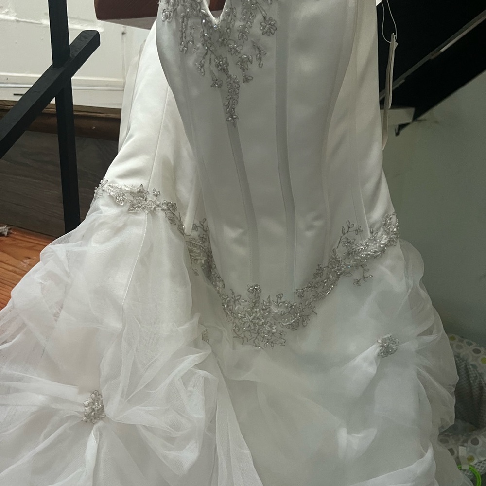 Wedding dress with tags never worn. Includes under skirt, tiara and veil .